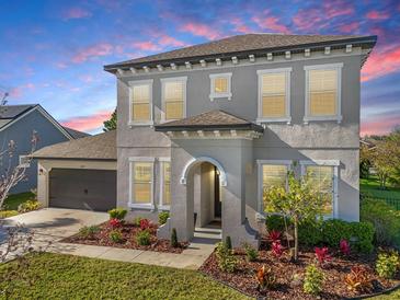 Charming two-story home featuring a stucco exterior, well-manicured landscaping and attached two car garage at 7122 Bowspirit Pl, Apollo Beach, FL 33572