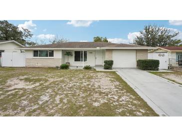 Charming single-story home features a well-maintained lawn, neutral paint, and an attached garage at 7740 Bracken Dr, Port Richey, FL 34668