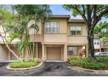 Charming townhome featuring a private garage, lush landscaping, and a welcoming entrance at 812 Normandy Trace Rd, Tampa, FL 33602