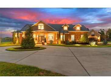 Beautiful sunset view of a home with manicured landscaping and circular driveway at 13206 Lewis Raulerson Road, Dover, FL 33527
