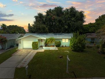 Charming single-story home with a well-manicured lawn, mature trees, and inviting curb appeal at 2523 Blackwood Cir, Clearwater, FL 33763