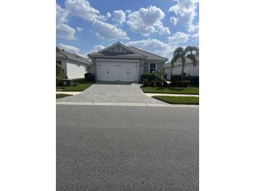 Charming single-story home with a two-car garage, manicured lawn, and a paved driveway at 953 Crosswind Ave, Sarasota, FL 34240