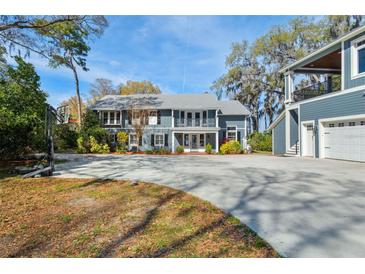 Charming two-story home with a large driveway, beautiful trees, and a basketball court for outdoor fun at 16573 Hutchison Rd, Odessa, FL 33556