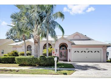 Charming home featuring beautiful palms, brick driveway, and a well-manicured lawn at 4823 Deer Lodge Rd, New Port Richey, FL 34655