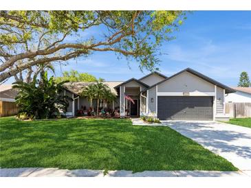 Charming single-story home boasts a well-manicured lawn, mature trees, and an inviting front entrance at 5441 Worthington Loop, Palm Harbor, FL 34685