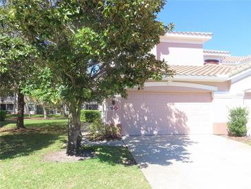 Charming home with a light-pink exterior and a well-manicured lawn at 829 Lantern Way # 829, Clearwater, FL 33765