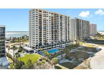 Beautiful high-rise condo with a beach view and a pool surrounded by palm trees on a sunny day at 1270 Gulf Blvd # 905, Clearwater Beach, FL 33767