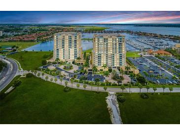Stunning aerial view of the condominium towers, lush landscaping, boat marina and surrounding bay waters at 140 Riviera Dunes Way # 404, Palmetto, FL 34221