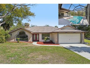 Charming single-story home with a manicured front lawn, red mulch accents, and a screened-in pool area at 14048 Bruni Dr, Spring Hill, FL 34609