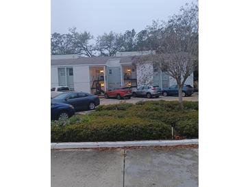 Multi-Gathering two-story residential complex with parking area, landscaping, and stairway access at 3801 N Oak Dr # A62, Tampa, FL 33611
