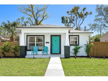 Charming home featuring a bright teal front door and cozy porch with matching blue chairs at 3854 12Th S Ave, St Petersburg, FL 33711