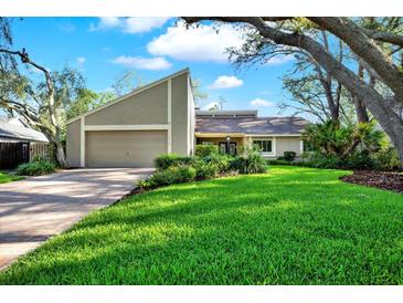 Charming single-Gathering home featuring well-maintained landscaping and a cozy two-car garage, perfect for suburban living at 11712 Palmer Dr, Tampa, FL 33624