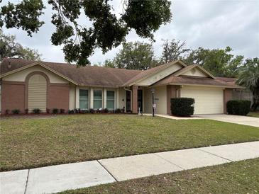 Charming single-story home with a well-maintained lawn, manicured landscaping, and an attached two-car garage at 1625 Carter Oaks Dr, Valrico, FL 33596