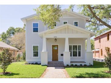 Charming two-story home with a light gray exterior, inviting front porch, and well-manicured lawn at 5337 6Th N Ave, St Petersburg, FL 33710
