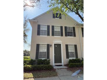 Charming two-story home with green shutters, a well-manicured lawn, and lovely landscaping at 10002 Bradwell Pl, Tampa, FL 33626