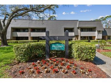 Inviting condo exterior with manicured landscaping, sign, and traditional architectural details at 36750 Us Highway 19 N # 01205, Palm Harbor, FL 34684