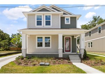 Charming two-story home featuring a welcoming front porch and professionally landscaped yard at 408 W Paris St, Tampa, FL 33604