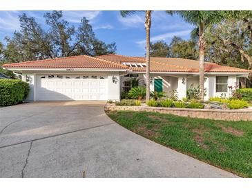 Charming single-story home with a tile roof, beautiful landscaping, and a two-car garage at 5473 Blue Heron Ln, Wesley Chapel, FL 33543