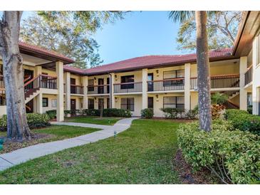 Inviting condo complex with lush landscaping, terracotta roof, and a neatly paved walkway at 1712 Hammock Pine Blvd # 1712, Clearwater, FL 33761