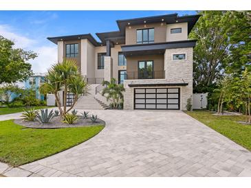 Modern home with a statement driveway, a two car garage, and manicured landscaping creating great curb appeal at 48 Sandpiper Rd, Tampa, FL 33609