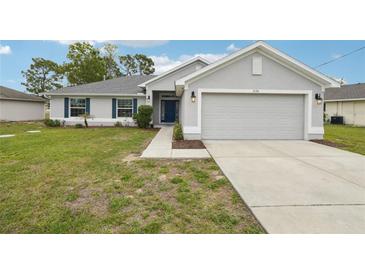 Charming home featuring a large garage, well-kept lawn, and freshly painted exterior at 5134 Jenson Ave, Spring Hill, FL 34608