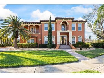 Stunning two-story home features a terracotta facade, lush landscaping, and a grand entrance at 5910 La Rosa Ln, Apollo Beach, FL 33572