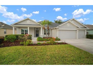 Beautiful single-story home with a well-maintained lawn, landscaped garden, and a welcoming front porch with decorative columns at 12339 Silton Peace Dr, Riverview, FL 33579