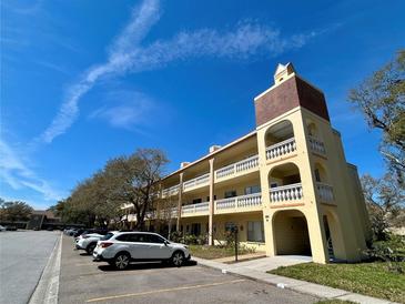 Multi-story condo building featuring balconies, stucco facade, and well-maintained landscaping under a sunny blue sky at 2226 Switzerland Way # 32, Clearwater, FL 33763