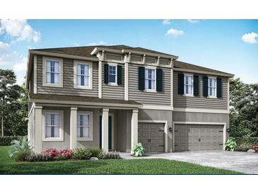 Charming two-story home with a two-car garage and lovely front yard landscaping at 2595 Wise River Ln, Zephyrhills, FL 33541