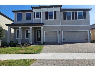 Charming two-story home featuring a two-car garage, manicured lawn, and classic architectural details at 2595 Wise River Ln, Zephyrhills, FL 33541