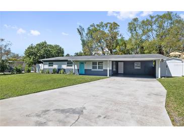 Charming single-story home featuring a spacious carport, lush lawn and inviting curb appeal at 311 W Fern St, Tampa, FL 33604