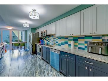 Charming kitchen featuring stainless steel appliances, and marble-look tile flooring at 4710 Bay Ne St # 109, St Petersburg, FL 33703