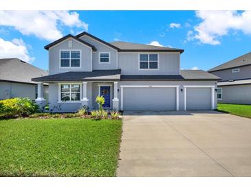 Charming two-story home with a three car garage, manicured lawn and a welcoming front porch at 11486 June Briar Loop, San Antonio, FL 33576