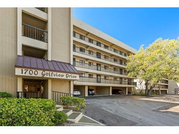 Condominium exterior showing covered parking, balconies, and the address 1700 Golfview Drive on a sunny day at 1728 Golfview Dr # 1728, Tarpon Springs, FL 34689