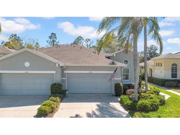 Charming home exterior featuring a well-manicured lawn and inviting two-car garage at 2082 Sifield Greens Way # 3, Sun City Center, FL 33573