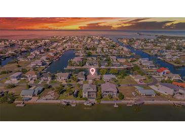 Stunning aerial view of waterfront homes with private docks and canal access at sunset at 4291 Flexer Dr, Hernando Beach, FL 34607