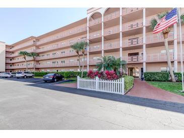 A condo building with balconies, palm trees, and an American flag at 5521 80Th N St # 315, St Petersburg, FL 33709