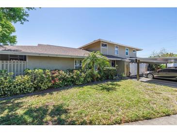 Charming home exterior with a lush, landscaped front yard and convenient carport at 6902 El Centro Ct, Tampa, FL 33634