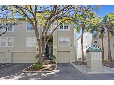 Inviting condo exterior with mature trees, attached garage, and well-maintained landscaping at 732 Coral Reef Dr # 732, Tampa, FL 33602