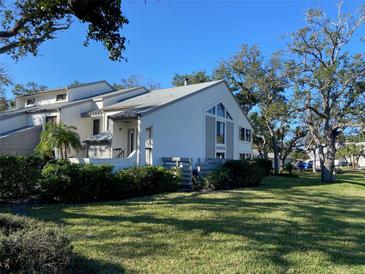 Charming home with landscaped yard, lush greenery, and a clear blue sky at 11450 Harbor Way # 5002, Largo, FL 33774