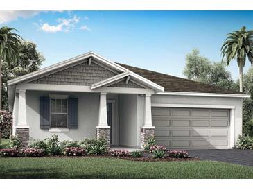 Charming single-story home featuring a two-car garage, landscaped front yard, and covered entryway at 12431 52Nd E St, Parrish, FL 34219