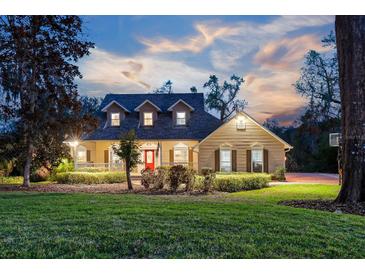 Charming two-story home with manicured landscaping and a welcoming red front door at 405 Apache Trl, Brandon, FL 33511