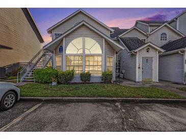 Inviting condo exterior with a large arched window and well-manicured lawn at dusk at 12253 Armenia Gables Cir # 12253, Tampa, FL 33612