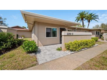 Inviting condo exterior with well-maintained landscaping, a neutral color palette, and stylish stone pavers at 2260 Oak Neck Rd # B, Clearwater, FL 33763