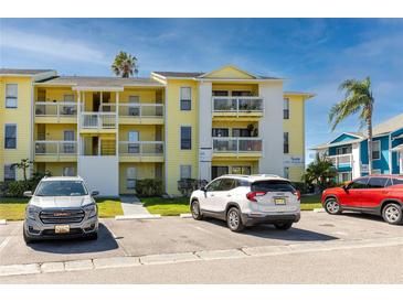 Inviting three-story condo building featuring balconies, palm trees, and convenient parking spaces for residents and guests at 455 Alt 19 S # 162, Palm Harbor, FL 34683