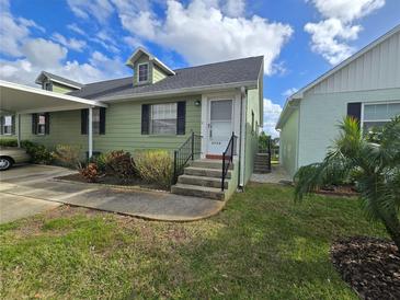 Charming exterior view of a home with green siding, black shutters, and well-maintained front yard at 6704 Hickorywood Ln # 2B, New Port Richey, FL 34653
