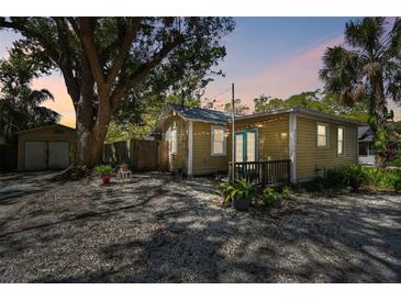 Charming home featuring a cozy backyard with pea gravel, string lights, mature trees, and a shed at 1588 S Prospect Ave, Clearwater, FL 33756