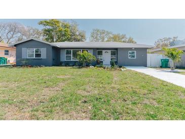 Charming home featuring a well-manicured lawn, freshly painted exterior, and lovely landscaping at 1605 Crown St, Clearwater, FL 33755