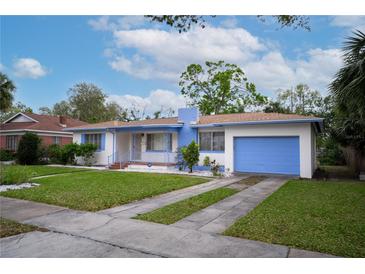 Charming single-story home with a blue painted garage door, and a well-manicured lawn at 2448 14Th S Ave, St Petersburg, FL 33712