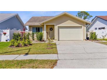 Charming home featuring a well-maintained lawn, complemented by manicured shrubs and an attached garage at 3329 Whispering N Dr, Largo, FL 33771